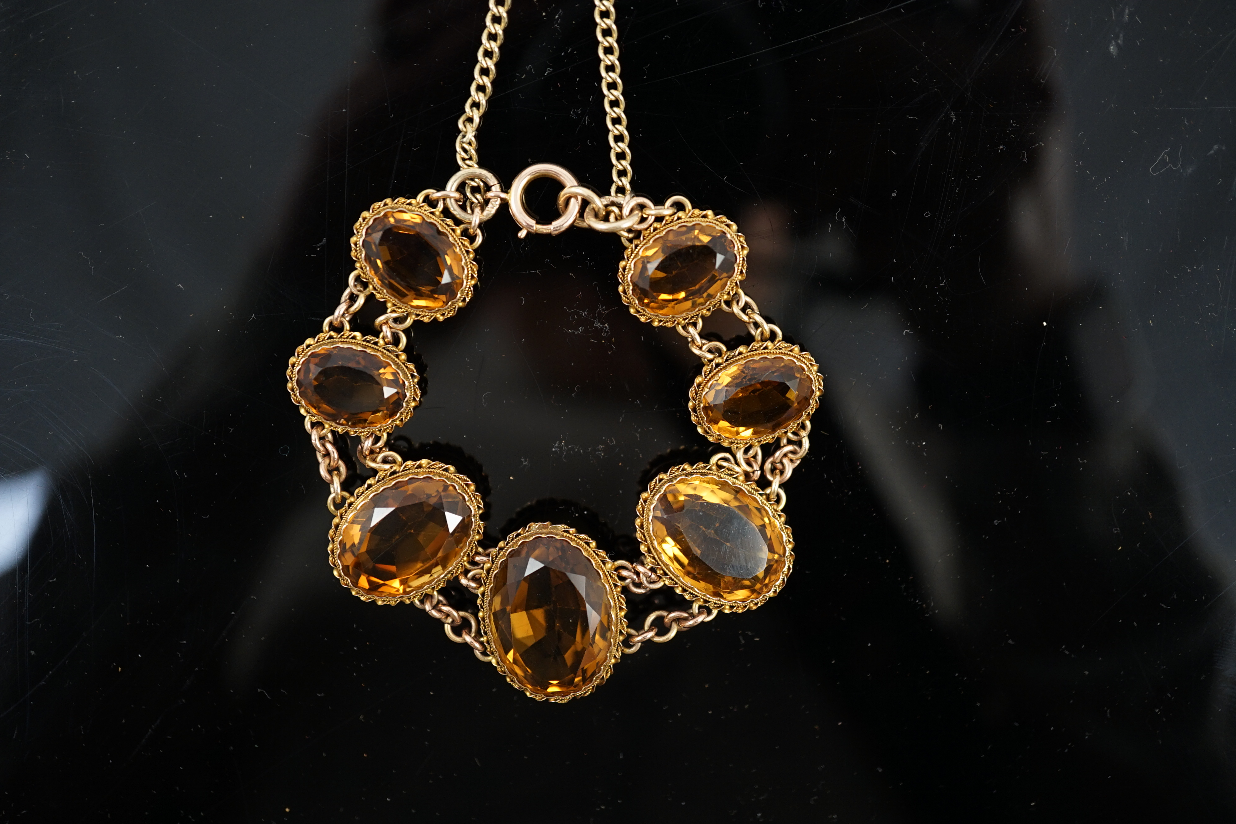 An early 20th century 9ct gold and graduated seven stone oval cut citrine set bracelet